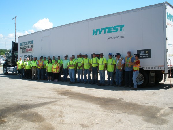 a Michigan trucking team posing in front of a semi-truck